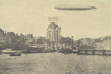 PBK-5298 Luchtschip Graf Zeppelin boven de Nieuwe Maas, bij de toegang tot de Oudehaven. Op de achtergrond het Witte Huis.