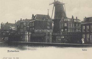 PBK-6250 Rotterdamse Schie met de spoorbrug, panden aan de westzijde van de Schiekade. Op de achtergrond molen De Haas.