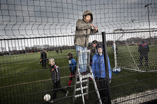 2013-22 Jongen repareert een net op een voetbalveld. De foto is gemaakt in opdracht van De Kracht van Rotterdam (DKVR).