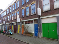 2023-35-388 Wolphaertstraat in Oud-Charlois met achter de gekleurde voordeuren creatieve ruimtes voor kunstenaars.