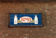 1986-2094 Tegelblok met R.M.I. vignet in het voormalige gebouw van de Rotterdamsche Melkinrichting aan de Blekerstraat 10.