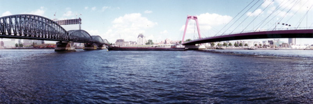 1987-1736 Gezicht vanaf de Maaskade op de Nieuwe Maas tussen de spoorbrug en de Willemsbrug.Aan de overzijde in het ...