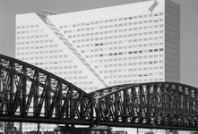 1989-3054 Deel van de spoorbrug over de Nieuwe Maas met op de achtergrond kantoorgebouw Willemswerf aan de Boompjes.