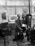 P-020658 Eugène Rensburg zittend in zijn atelier bij zijn schildersezel met palet en kwast in de hand .