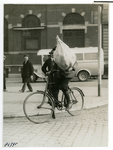 1967-130 Een man met een jute zak fiets vakkundig over de kasseien.