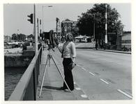 1975-821 De fotograaf M.K van Essen van de Gemeentelijke Archiefdienst maakt opnamen op de Spoorweghavenbrug, met op de ...