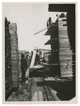 1976-14496 Versjouwen van houten planken bij het Blauwhoedenveem.