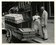 1984-2214 Een broodbezorger van J. Jansse Wz. bakkerijen verkoopt met behulp van een bakfiets brood aan huis.