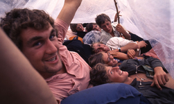 2006-47-029 Diareportage van het Holland Popfestival in het Kralingse Bos (29): jongeren die schuilen onder een plastic zeil.