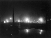 VIII-23-00-00-04 De Delftsevaart met galerijbrug bij avond, uit het zuiden. Op de achtergrond het Hofplein.