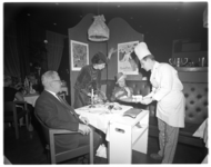 12248 Een kok serveert tijdens Toulouse Lautrec-avond in het Rijnhotel.