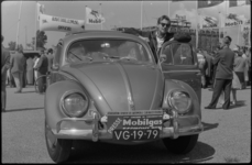 1655-1 (Pers-)deelnemer met een Volkswagen-Kever staat op het parkeerterrein aan de Karel Doormanstraat bij de eerste ...
