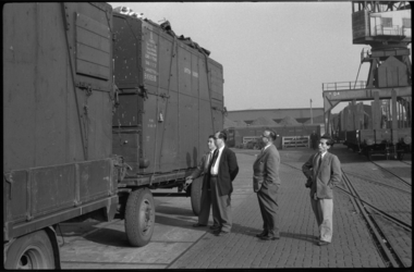1820 Mannen kijken naar containers op een vrachtauto. De inhoud daarvan betreft Japanse kunstschatten die zijn ...