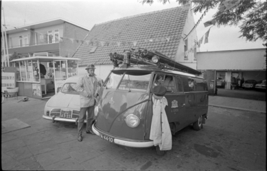 21427-2-11 Brandweerman staat naast kleine bluswagen 'A. Cupedo' bij garage, naast tankstation aan de Grindweg in ...