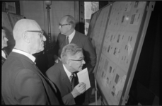 21559-7-34 De heer A.G. de Vries, hoofddirecteur van de Posterijen, toont Rotterdams burgemeester Wim Thomassen de ...