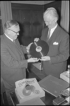 22470-7 G.M. Dersjant (rechts) bekijkt samen met drs. E. van Gulik, directeur Gemeentebibliotheek, een grammofoonplaat.