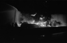 22523-3-31 Brandbestrijders bij een in brand staande en ineengezakte opslagtank.
