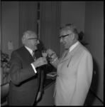 23551-4-12 Kamerbewaarder L. Scheepers en burgemeester W. Thomassen brengen dronk uit 'op elkaar' bij afscheid stadhuisbode.