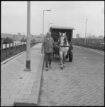 24912-1-1 Melkboer van der Ben met paard en wagen. Op de achtergrond de wijk Ommoord.