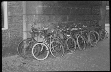 3054-1 Een aantal verwaarloosde fietsen tegen muur in onderdoorgang.