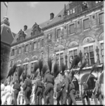 8022-2 Groep mannen in werkkleding marcheert langs het stadhuis met bezems op hun schouder tijdens de optocht in het ...