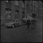 8830 Drie jongemannen poseren voor het gebouw van de Technische School aan de Hillevliet bij een reclamemodel van een ...