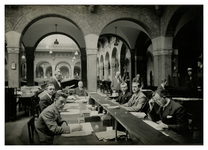 XII-52-04-1 Ambtenaren van Bureau Bevolking in het stadhuis aan de Coolsingel aan het werk aan lange bureaus.