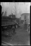 THO-108 Kind speelt in een plas in een woonwagenkamp aan de Oude Kleiweg. Links een oplegger met golfplaten.