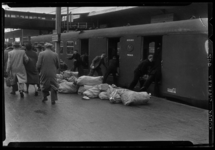 THO-1168 Medewerkers van de PTT en de NS laden postzakken in een trein op station Delftsche Poort. Uit een serie over ...