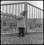 THO-1252 Een meisje staat bij het hek van een speeltuin.