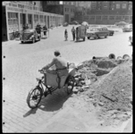 THO-1531 Straatbeeld van de Brandersplaats. Op de voorgrond pauzeert een man op zijn fietskar na graafwerkzaamheden. Op ...