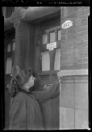THO-186 Een jonge vrouw staat voor de deur van Pension Verhagen aan de Mathenesserlaan 357a. Bij een artikel over ...