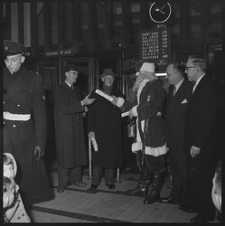 THO-1927 De kerstman overhandigt cadeaus en ontsteekt de feestverlichting bij het Colosseum Theater aan de Beijerlandselaan.