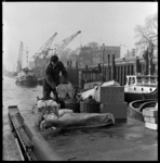 THO-1951 Bij de Westerkade brengt een man voedsel en drinken naar een zeeschip.