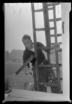 THO-198 Glazenwasser J.J. van der Klift wast vanaf een ladder de ramen van een woning aan de 2e Gijsingstraat. Gezien ...