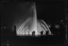 THO-375 In de avond kijken bezoekers naar de verlichte fonteinen in het Park tijdens de manifestatie E '55.