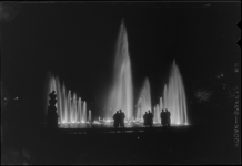 THO-376 In de avond kijken bezoekers naar de verlichte fonteinen in het Park tijdens de manifestatie E '55.