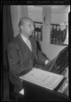 THO-849 In zijn woning zit arts L. Huibregtsen achter zijn piano. Hij oefent voor een uitvoering met het Rotterdamsch ...