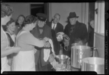 THO-965 Leden van de Unie van Vrouwelijke Vrijwilligers (UVV) delen maaltijden uit aan ouderen in de keuken van het ...