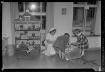 THO-981 Een zusters van het Sophia Kinderziekenhuis aan de Gordelweg zit bij kinderen in de speelkamer. Kinderen spelen ...