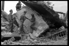 1980-5129 Soldaten bewerken met een drilboor grote brokstukken gewapend beton in het door het bombardement van 14 mei ...