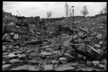 1980-5141 De door het bombardement van 14 mei 1940 getroffen Sionstraat. Tussen het puin ligt een straatnaambord.