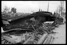 1980-5150 In de Leuvehaven ligt een zwaar beschadigd schip als gevolg van het bombardement van 14 mei 1940.