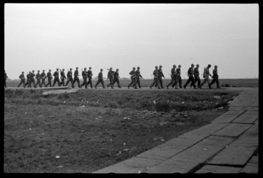 1980-5606 Kort na de bevrijding loopt een grote groep mannen van de Binnenlandse Strijdkrachten (B.S.) over een dijkje, ...