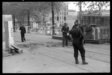 1980-5611 Twee gewapende mannen houden de wacht bij een Duitse antitankmuur in de Scheepstimmermanslaan kort na de ...