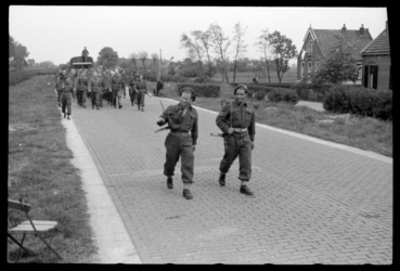 1980-5631 Duitse krijgsgevangen lopen onder geallieerde bewaking over de Hoofdweg bij Terbregge. Bij een boerderij ...