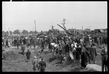 1980-5678 Grote groepen mensen kijken in het centrum in het gras naar een optocht van het Canadese leger. Op de ...
