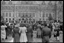 1980-5750 Een menigte mensen staat voor het stadhuis op de Coolsingel. Ze kijken en zwaaien naar Winston Churchill op ...
