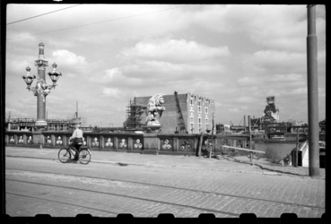 1980-5797 Een man fiets over de Regentessebrug. Rechts nieuwe panden aan de Wijnhaven in aanbouw. Geheel rechts is het ...