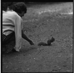 85-01 In het Kralingse Bos geeft een jonge vrouw een eekhoorn te eten.